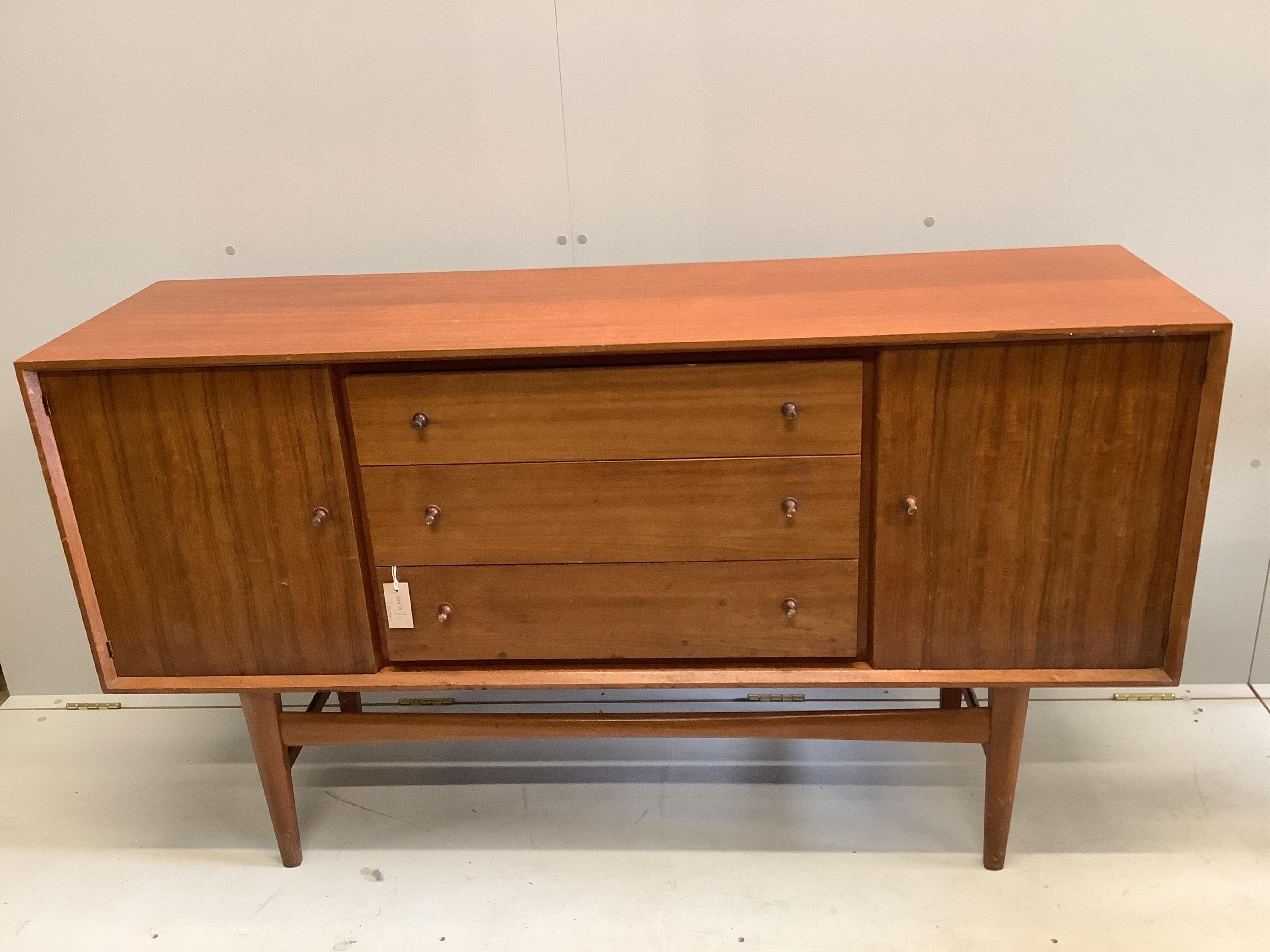 A mid century Gordon Russell teak dining suite comprising rectangular extending table, twelve chairs and a sideboard, width 140cm, depth 80cm, height 74cm. Condition - fair, with the leaf in it's an eight seater